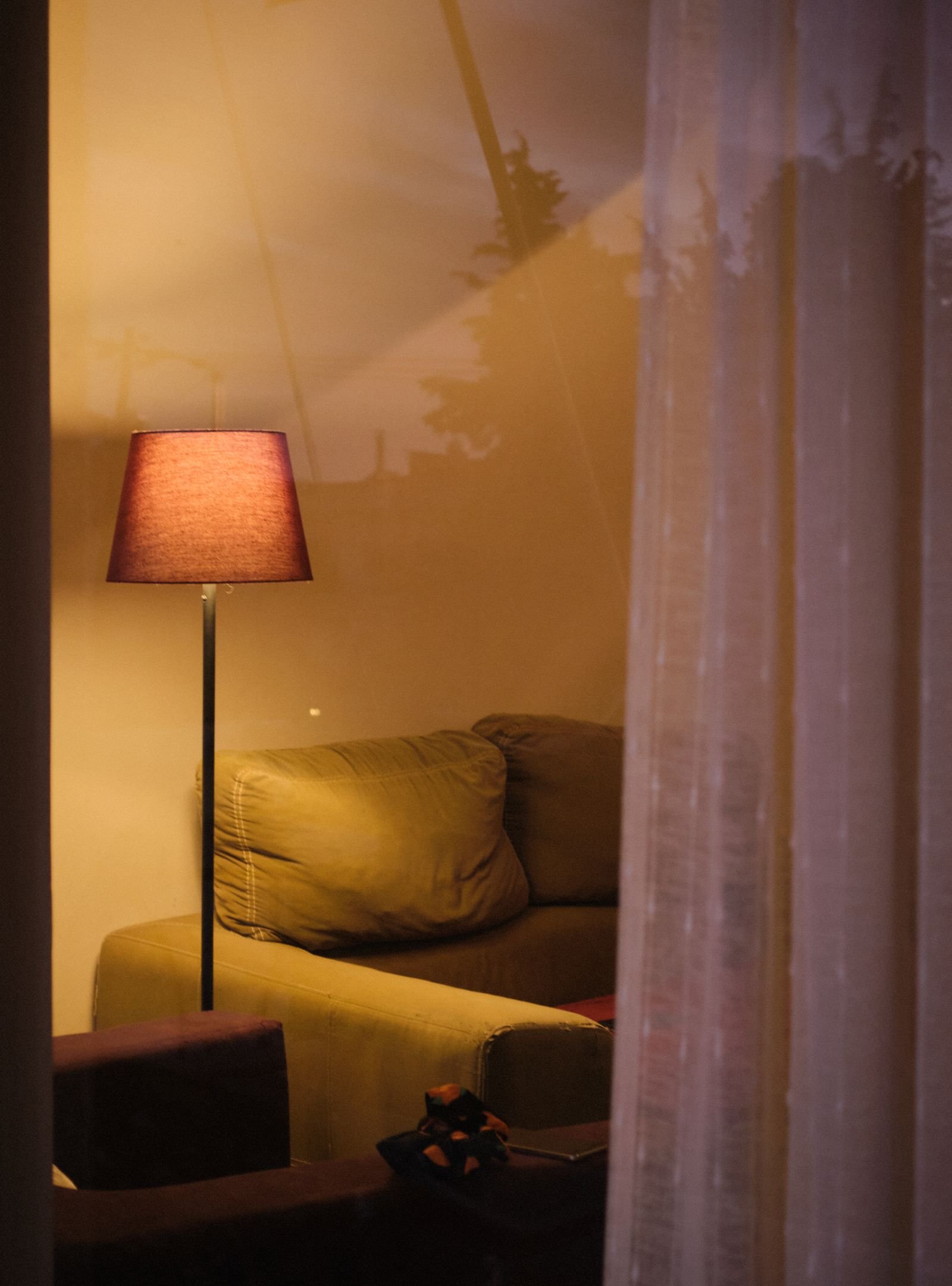 Cozy living room with layered lighting from a floor lamp, table lamp, and warm pendant light