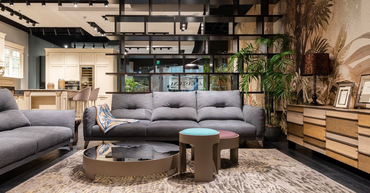 10 Cozy Living Room Ideas on a Budget Living room with gray sectional sofa, round coffee table, and plants on a wooden sideboard